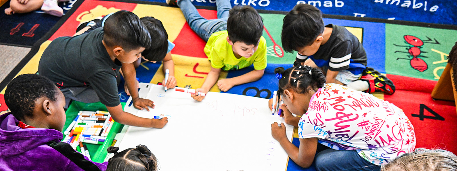 students lay on the floor drawing