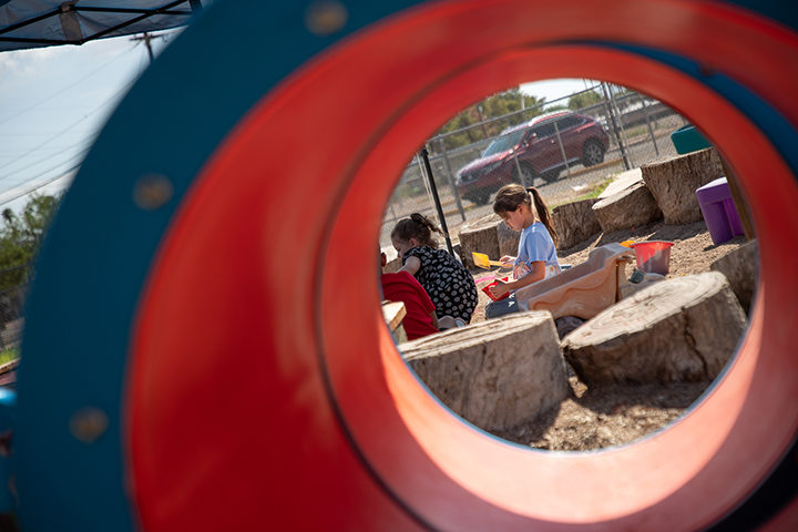 A photo of students on the playground as taken through the play tunnel