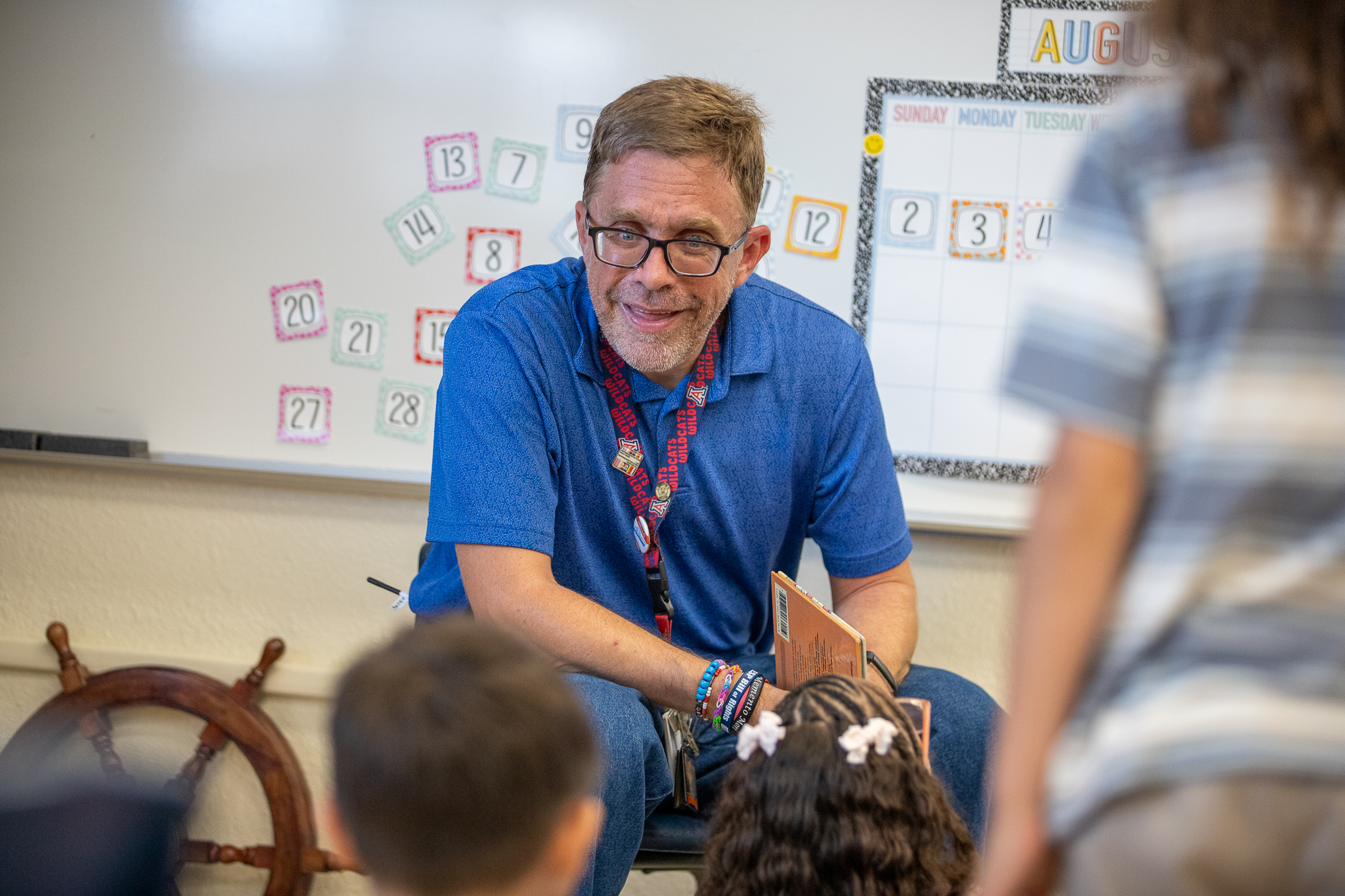 A teacher gets ready to read a book to his students