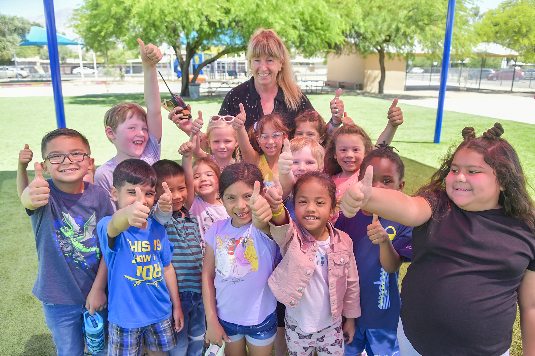 Students smile and give a thumbs up out in the courtyard